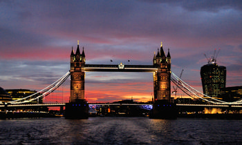 Tower bridge sunset This urban landscape photograph captures London’s iconic Tower Bridge at sunset during the evening in early autumn. The illuminated architecture of the bridge stands out against the vibrant sky, which is painted with shades of orange, red, and purple as the sun sets over the city. The image showcases one of the United Kingdom’s most famous bridges and highlights the unique blend of historical and modern design characteristic of London. City lights begin to sparkle around the urban waterfront, further emphasizing the architectural features of Tower Bridge in this prominent city setting.